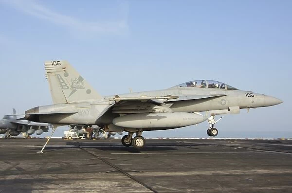 An F  /  A-18E Super Hornet makes an arrested landing aboard an aircraft carrier