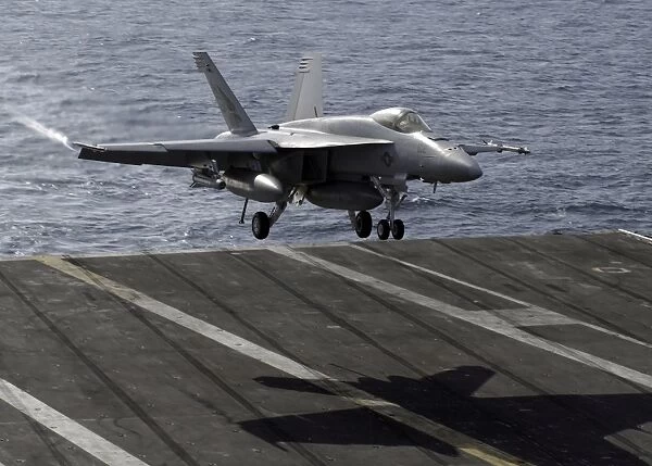 An F  /  A-18E Super Hornet prepares to land on the flight deck aboard USS Dwight D