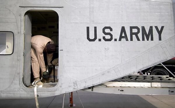 Flight Engineer secures equipment inside the cargo compartment of his C-23B Sherpa