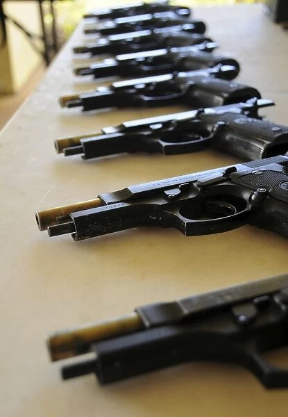 Handguns lined up on a table