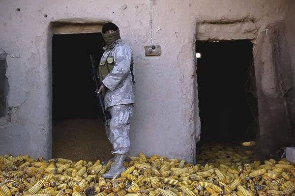 An Iraqi army soldier checks a storage room during an operation to find weapons caches