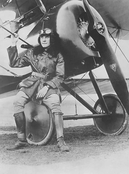 Lieutenant Earl Carroll seated on the wheel of his fast scout airplane