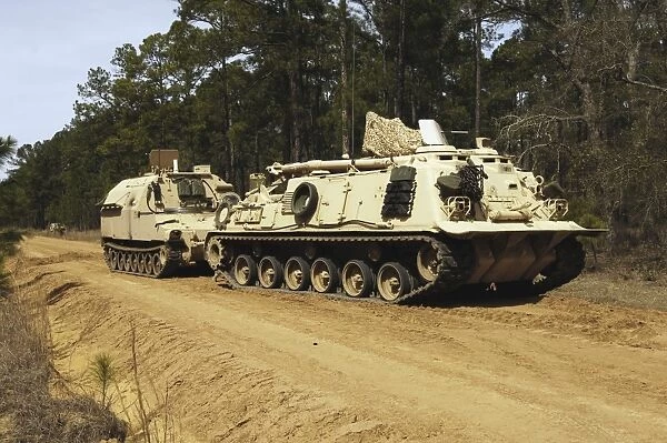 An M-88 recovery vehicle begins to tow an M992 field artillery ammunition supply vehicle