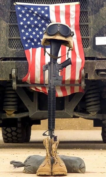 An M16-A2 service rifle, a pair of boots and a helmet stand in tribute to a fallen