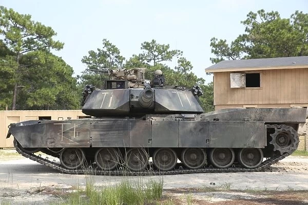 An M1A1 Abrams tank takes a defensive position on a simulated enemy town