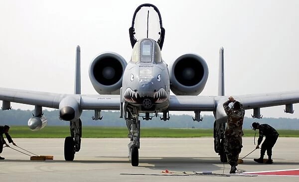 Maintainers place the chocks under an A-10C Thunderbolt II