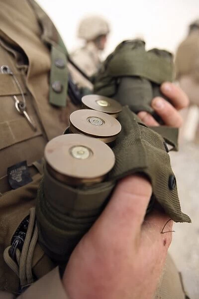 A Marine cradles handfuls of 40 mm grenades