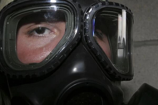 A Marine glares through the limited-spaced eye protection part of his gas mask
