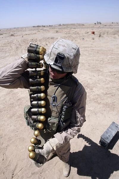A marine handles a string of 40 mm high-explosive grenades