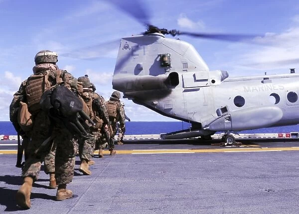 Marines board a CH-46E Sea Knight helicopter aboard USS Essex