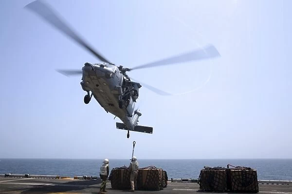 Marines hook cargo to an MH-60S Sea Hawk helicopter