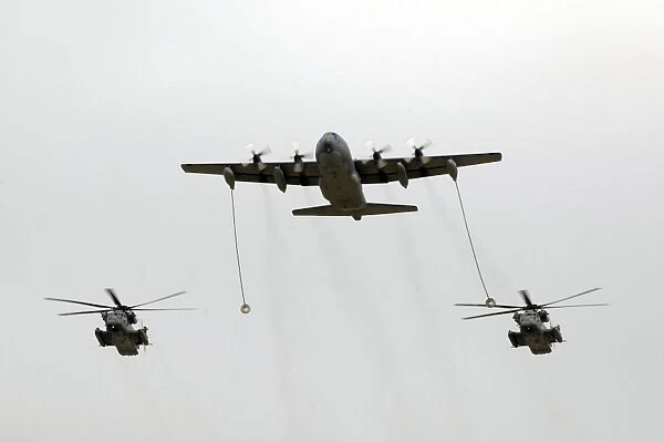 A MC-130W conducts an in-flight refueling for two MH-53J Pave Low III helicopters