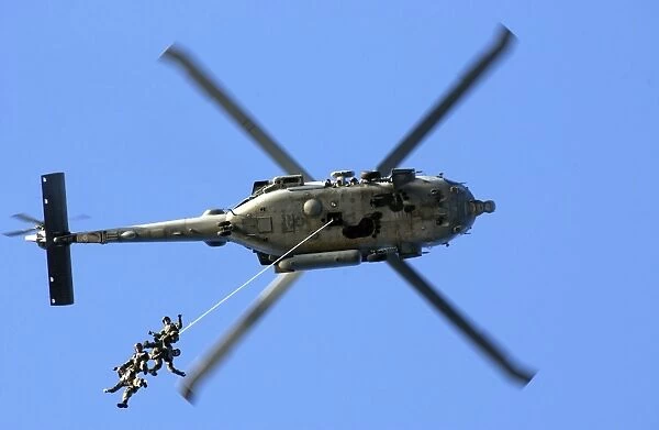 Members conduct a helicopter rope suspension techniques exercise from a SH-60F Seahawk