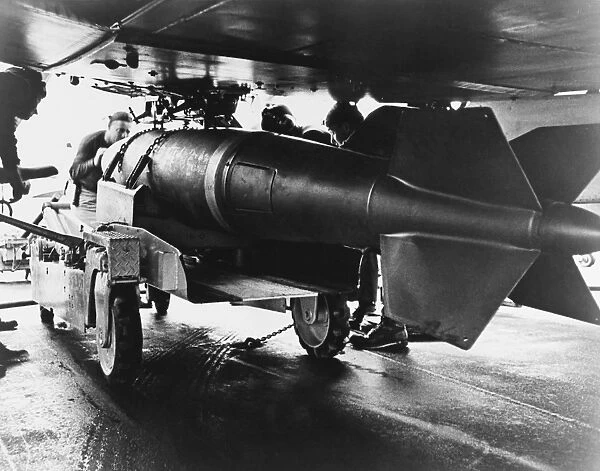 Men aboardUSS Ranger position a 2, 000 pound bomb under the wing of an A-1 Skyraider, 1965