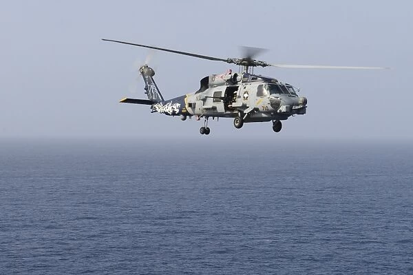 An MH-60R Sea Hawk helicopter flies over the Gulf of Oman
