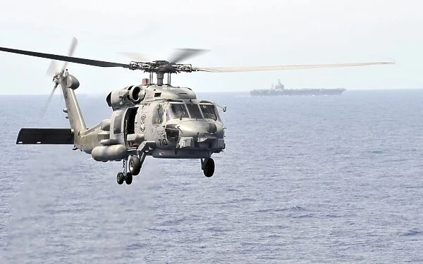 An MH-60R Seahawk helicopter in flight over the Pacific Ocean