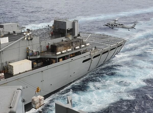 An MH-60S Sea Hawk conducts a vertical replenishment at sea