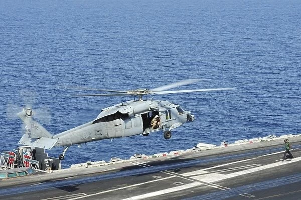 An MH-60S Sea Hawk helicopter lands on the flight deck of USS George H. W. Bush