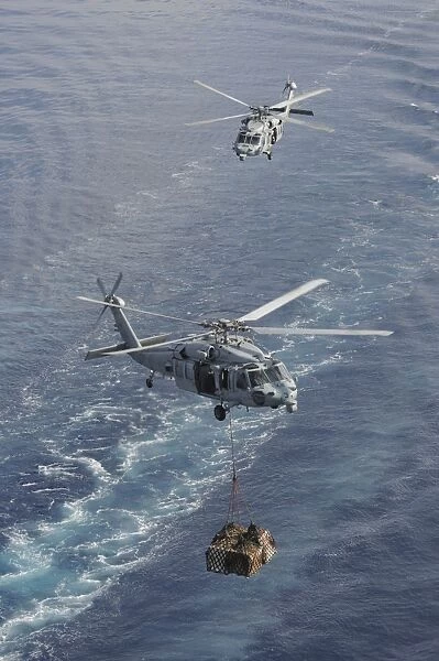 Two MH-60S Sea Hawk helicopters transport supplies