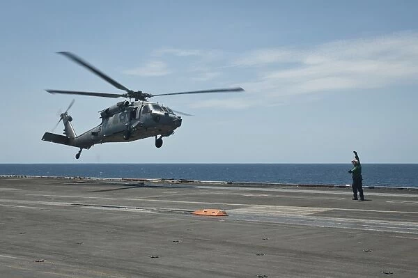 An MH-60S Sea Hawk prepares to land on the flight deck of USS Nimitz