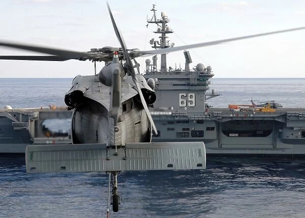 An MH-60S Seahawk hovers prior to taking a load of ammunition to USS Dwight D. Eisenhower