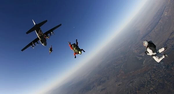 Several military freefall parachutist course students exit an aircraft