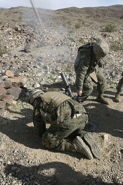 Mortarmen cover their ears and avert their eyes after firing their 60mm mortar weapons