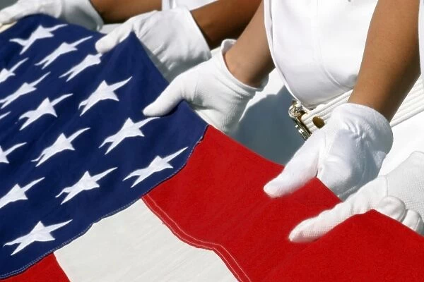 A Naval Station Pearl Harbor Ceremonial Guard folds the National Ensign during a