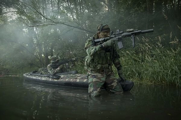 Navy SEALs navigate the waters in a folding kayak during jungle warfare operations
