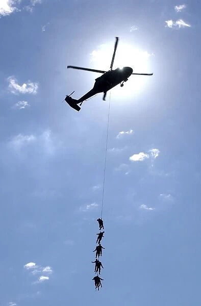 oldiers and Airmen hang 100 feet above the ground from a UH-60 Blackhawk