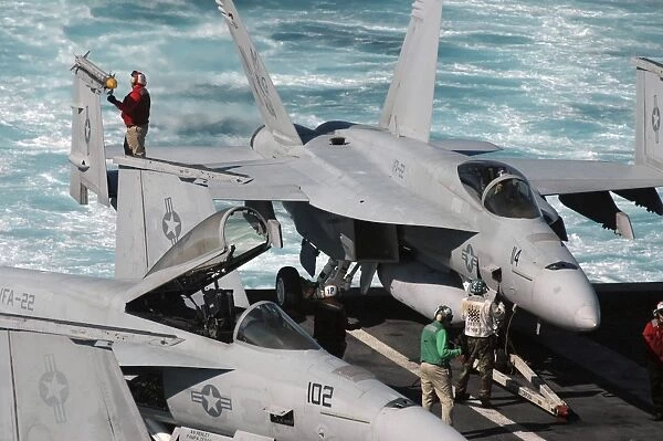 Ordnancemen perform checks on a F  /  A-18E Super Hornet aircraft