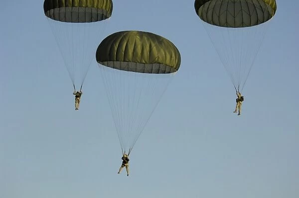 Paratroopers descend through the sky