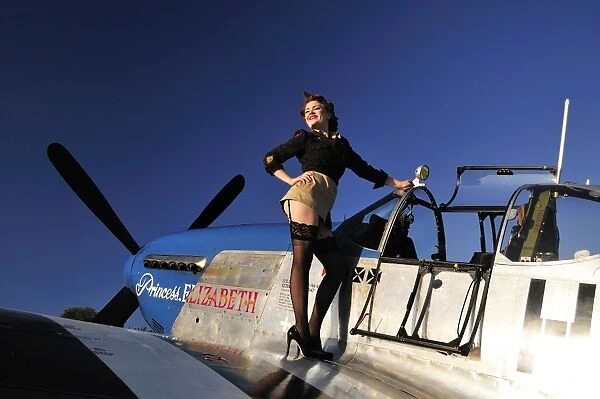 Pin-up girl standing on the wing of a P-51 Mustang