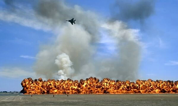 Pyrotechnics explode while an F-15 flies over to simulate an air-to-ground attack