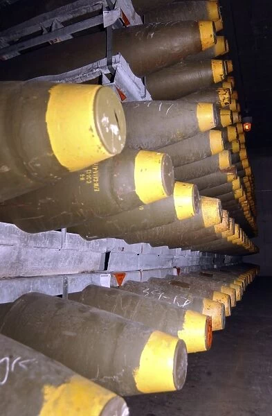 Racks of bombs sit inside the interior of a warehouse