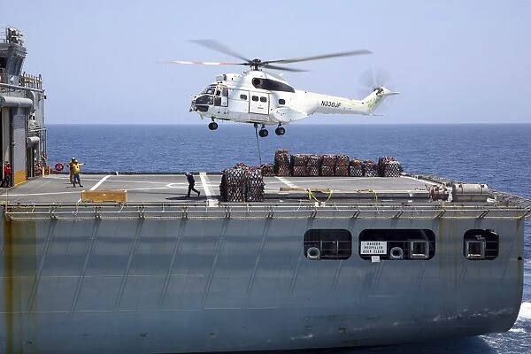 An SA-330J Puma helicopter delivers supplies to USS Kearsarge