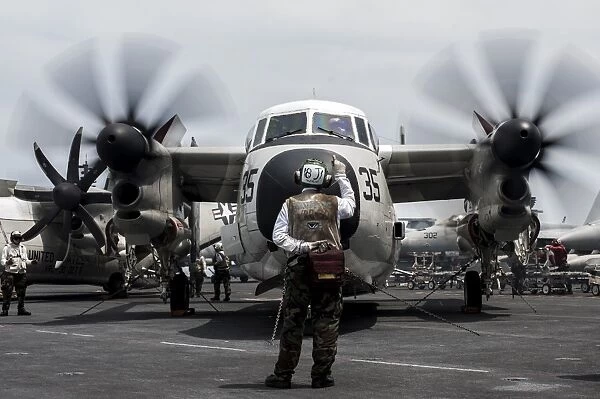 A Sailor directs a C-2A Greyhound on the flight deck of USS George Washington