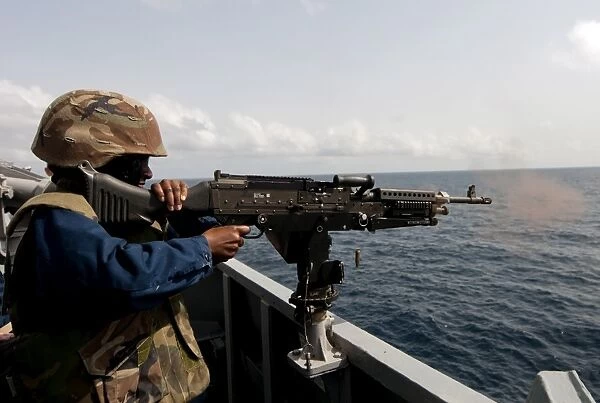 Sailor fires a M240B machine gun aboard USS Winston S. Churchill