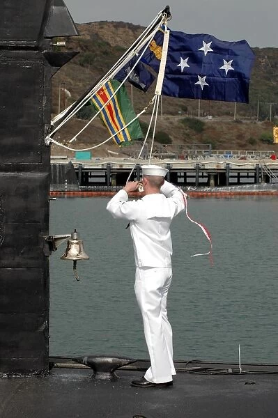 Sailor hauls down the commissioning pennant for the fast attack submarine USS Salt