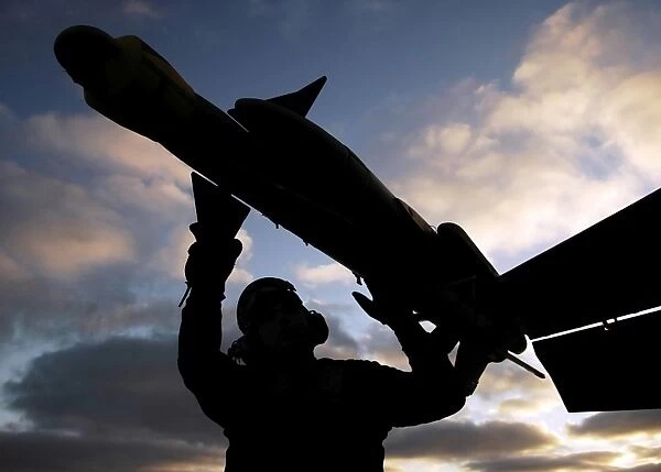 A Sailor inspects a Captive Air Training Missile attached to an F  /  A-18F Super Hornet