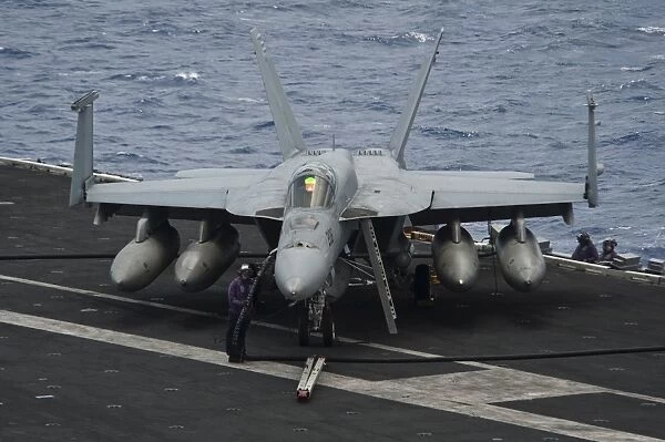 A sailor refuels an F  /  A-18E Super Hornet