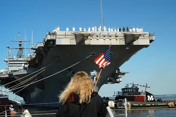 Sailors aboard aircraft carrier USS Enterprise man the rails