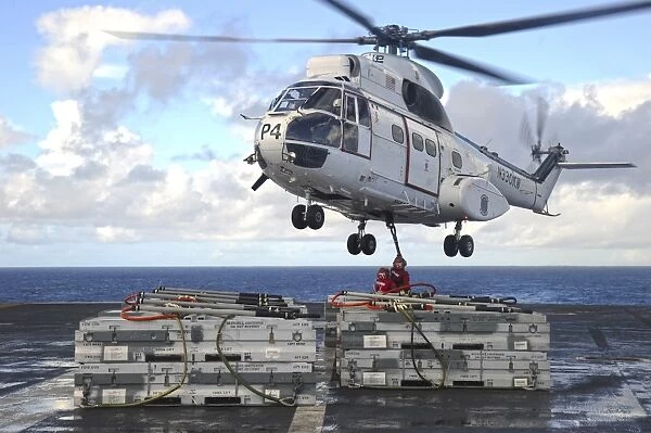 Sailors attach cargo legs to an SA330J Puma helicopter