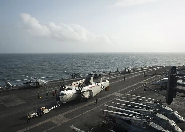 Sailors move a C-2A Greyhound across the flight deck of USS Nimitz