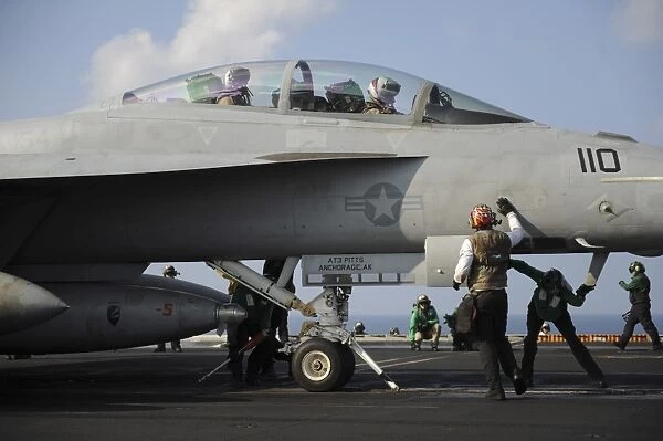 Sailors check an F  /  A-18F Super Hornet prior to take off