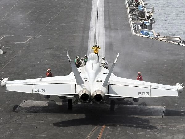 Sailors perform pre-launch checks on an EA-18G Growler