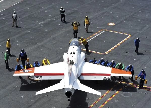 Sailors push a T-45C Goshawk on the flight deck of USS Ronald Reagan