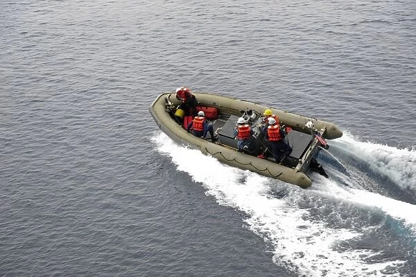 Sailors in a rigid-hull inflatable boat conduct boat operations