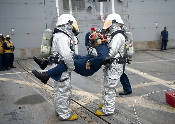 Sailors simulate rescuing a pilot during a crash and salvage drill