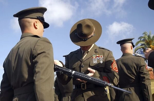 A senior drill instructor inspects a recruits rifle for cleanliness